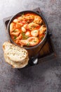 Brudet or Brodetto tasty stew of fish, seafood such as shrimps, scallops, calamari, mussels close-up in a bowl. Vertical top view