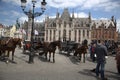 Bruge Belgium. Main square with three horse and trap waiting for tourists