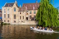 BRUGES, BELGIUM - APRIL 6, 2008: Tourists float on a boat through the Dijver channel Royalty Free Stock Photo