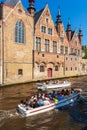 BRUGES, BELGIUM - APRIL 6, 2008: Tourists float on a boat through the Dijver channel Royalty Free Stock Photo