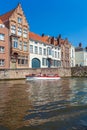 BRUGES, BELGIUM - APRIL 6, 2008: Tourists float on a boat through the Dijver channel Royalty Free Stock Photo