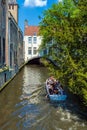 BRUGES, BELGIUM - APRIL 6, 2008: Tourists float on a boat through the Dijver channel Royalty Free Stock Photo