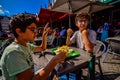 Bruges, Belgium, August 2019. A chip shop overlooking the touristy Markt square. Two Caucasian boys are enjoying the chips with Royalty Free Stock Photo