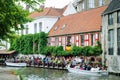 Bruges, Belgium - August 2010: Tourists standing in a queue on the pier for their boat trip along the canals of the city