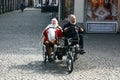 BRUGES, BELGIUM- 03. 26.2018 Elderly couple tourists ride a side by side tandem bicycle.
