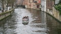 Tourist sightseeing boat on canal in Bruges in winter, Bruges, Belgium Royalty Free Stock Photo