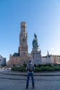 Bruges, Belgium 02/29/2020.  Guy with back pack is looking at Brugge Belfry tower facade Royalty Free Stock Photo