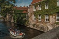 Tourist boat on canal and brick building at Bruges. Royalty Free Stock Photo