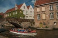 Tourist boat on canal and brick building at Bruges. Royalty Free Stock Photo