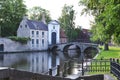 BRUGES, BELGIUM - JUNE 14, 2019: Bridge over canal and entrance gate to the Princely Beguinage Ten Wijngaerde Royalty Free Stock Photo