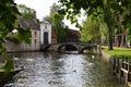 BRUGES, BELGIUM - JUNE 14, 2019: Bridge over canal and entrance gate to the Princely Beguinage Ten Wijngaerde Royalty Free Stock Photo