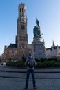 Men is looking at Brugge Belfry tower facade of famous tourist destination at Grote markt square in Bruges Royalty Free Stock Photo