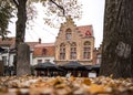 Brugge, Belgium autumn street scene with tourists and shoppers visiting tourist attractions leaves on the ground. Royalty Free Stock Photo