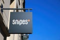 Closeup of snipes sneakers logo lettering above store against blue sky