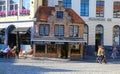 View over shopping street on old isolated lost medieval brick house chocolatier between modern buildings Royalty Free Stock Photo