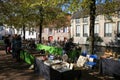 View on tables of flea market under trees at water canal Royalty Free Stock Photo