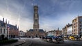 Horse Drawn Carriages at Sunrise on the Market Square in Bruges with many Historic Buildings and famous Belfry Tower