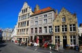 View over square on medieval buildings with restaurant bar and people sitting exterior on sunny day