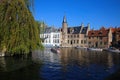 View over water canal on pier with tourist sightseeing boats, medieval buildings, green tree against clear blue autumn sky Royalty Free Stock Photo