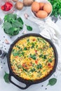 Brunch egg frittata with spinach, roasted red peppers, mushrooms, in cast iron, vertical, top view Royalty Free Stock Photo