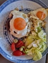 Brunch with fried eggs and salad on chinese playe