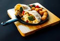 Brunch menu Breakfast burrito with scrambled eggs, broccoli, tomatoes, hash brown on a black pan and wooden plate Royalty Free Stock Photo