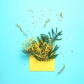 Brunches of yellow mimosa flower in envolope on yellow background. Top view. Copy space. Spring and Woman day concept Royalty Free Stock Photo