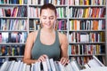 Brunete girl chooses a book in university library Royalty Free Stock Photo