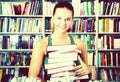 Brunete girl chose a lot of books in university library Royalty Free Stock Photo
