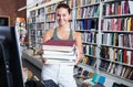 Brunete girl chose a lot of books in university library Royalty Free Stock Photo