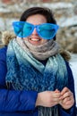 Brunette adult girl in big clown glasses with scarf, smiling, standing alone outdoor in the cold winter Royalty Free Stock Photo