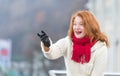 Brunette aged woman in white coat. Rude attractive lady with red lips and red scurf. Aged woman happy welcome on street.