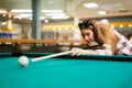 Brunette aiming while playing snooker