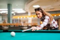 Brunette aiming while playing snooker