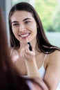 Brunette applying lip gloss Royalty Free Stock Photo