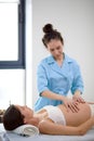 Mom-to-be receiving osteopathic treatment in clinic. therapist manipulates belly