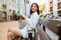 Brunette asian woman smiling and reading book while sitting on bench Royalty Free Stock Photo