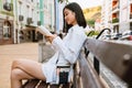 Brunette asian woman smiling and reading book while sitting on bench Royalty Free Stock Photo