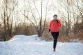 Brunette athlete running in winter park on morning run Royalty Free Stock Photo