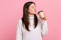 Brunette attractive woman smelling and enjoying tasty aromat of hot coffee, hot morning beverage. Royalty Free Stock Photo