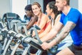 Side view of a beautiful woman smiling while cycling at the gym Royalty Free Stock Photo