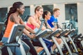 Side view of a beautiful woman smiling while cycling at the gym