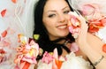 Brunette bride on the bed covered with rose leaves Royalty Free Stock Photo