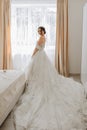 brunette bride in a chic dress with a long train in her room Royalty Free Stock Photo