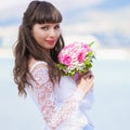 Brunette bride sea background with bouquet Royalty Free Stock Photo