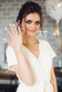 Brunette bride showing hand with wedding ring and hiding face. Royalty Free Stock Photo