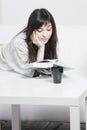 Brunette in casual reading on couch closeup