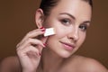 Brunette caucasian woman apply foundation with a sponger. Flawless clean skin. Beauty skin care concept Royalty Free Stock Photo