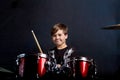 A brunette child boy plays the drums. Studying in the studio.