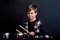 A brunette child boy plays the drums. Studying in the studio. Royalty Free Stock Photo